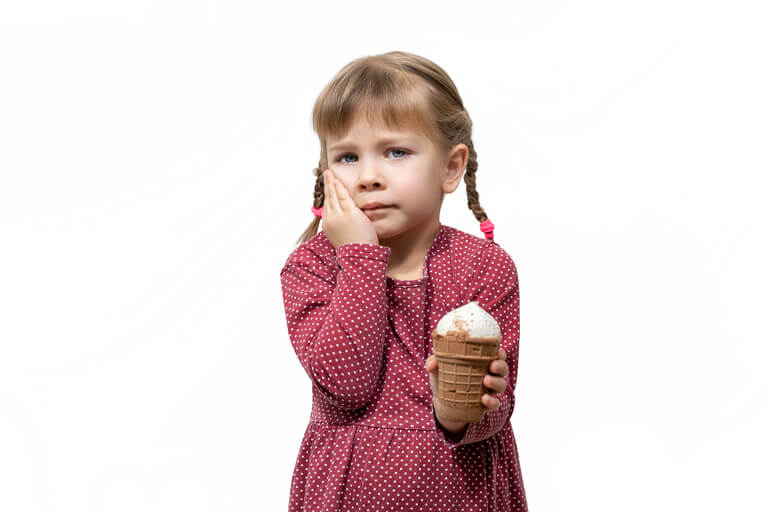 Devojcica koju boli zub drzi sladoled